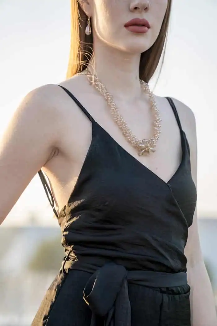 Home woman wearing black spaghetti strap dress and gold colored necklace 1454180 1