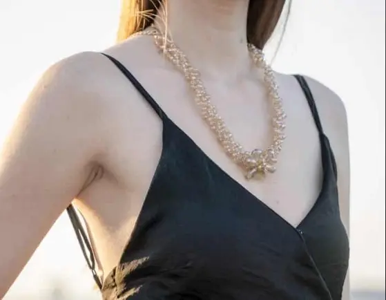 Home woman wearing black spaghetti strap dress and gold colored necklace 1454180